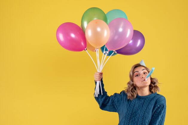 颜色正面图：带着彩色气球的年轻女性庆祝生日五颜六色