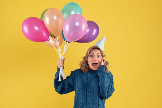女人正面图：带着彩色气球的年轻女性五颜六色乐趣空气