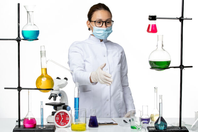 专业前视图：穿着医疗服面具的女化学家在白色背景上问候某人病毒化学实验室covid-飞溅医院医生医疗