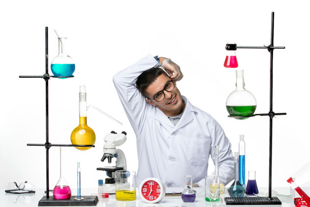 视图正面图身着白色医疗服的男性化学家坐在白色背景上微笑着病毒科学病毒-大流行实验室人微笑实验室