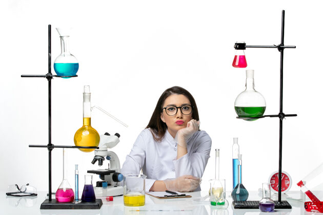 桌子前视图穿着医疗服的女化学家围坐在桌子旁 在白色背景上解决实验室病毒冠状病毒大流行的科学罐子医疗周围