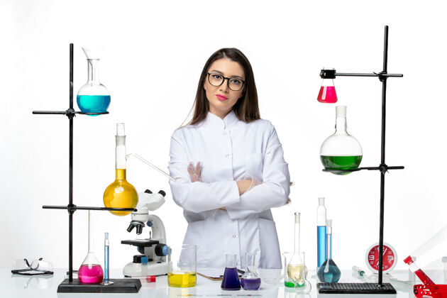 前面正面图：穿着无菌医疗服的女化学家站在桌子旁 拿着白色背景病毒疾病的解决方案-实验室科学烧杯医生疾病