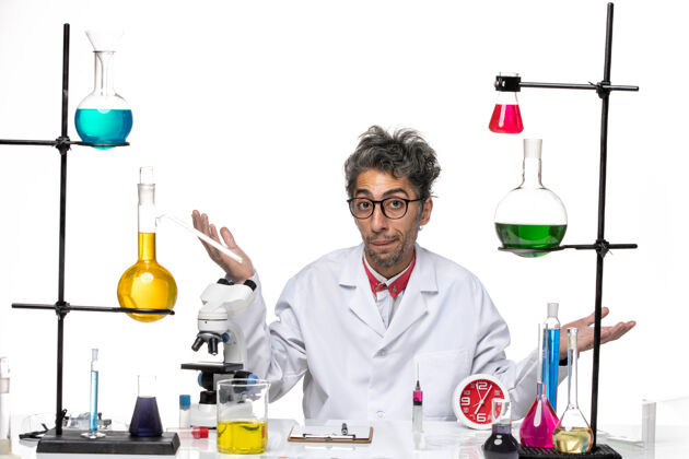 桌子前视图穿着医疗服的男科学家坐在桌子前 用白色背景的化学试剂解决实验室病毒健康问题医生实验室医疗