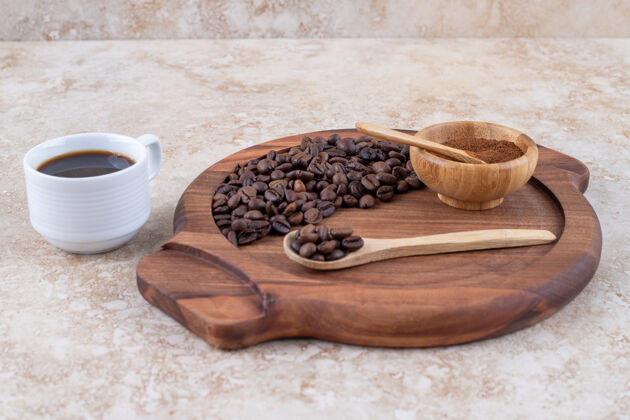 咖啡一个盘子 上面放着磨碎的咖啡豆 旁边放着一杯咖啡芳香美味研磨