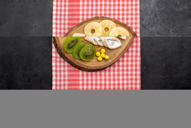包俯瞰美味的糕点与干菠萝环和猕猴桃在深灰色的空间干的晚餐菠萝