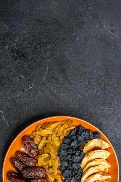 盘子在灰色的桌子上 盘子里放着葡萄干的干果水果美味葡萄干