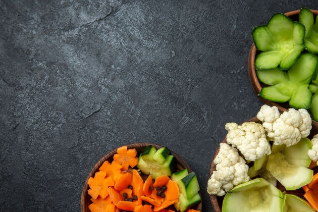 设计顶视图不同设计的蔬菜在深灰色的空间内锅一餐生的沙拉