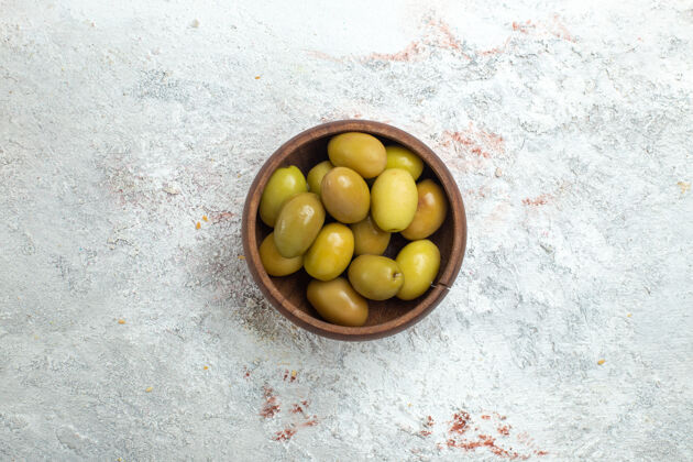 可食用的水果顶视图绿色橄榄在白色空间的小盘子里绿色顶部里面