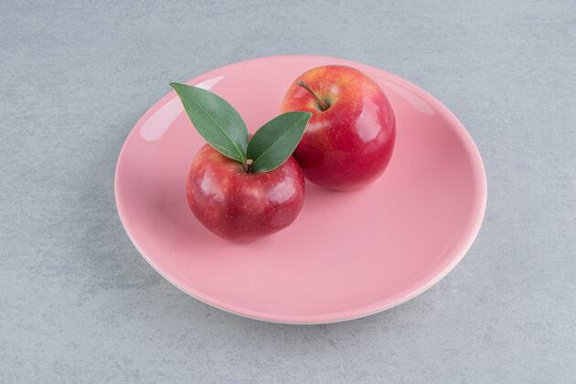 美味新鲜苹果放在大理石上的粉红色盘子里水果多汁配料