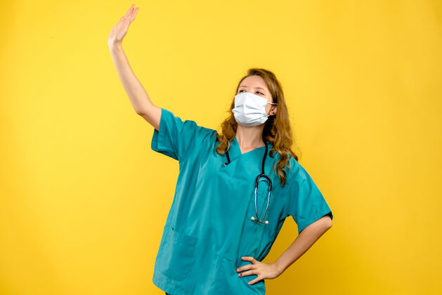 保健黄色墙壁上 女医生戴着面具在招手医生女医生挥手