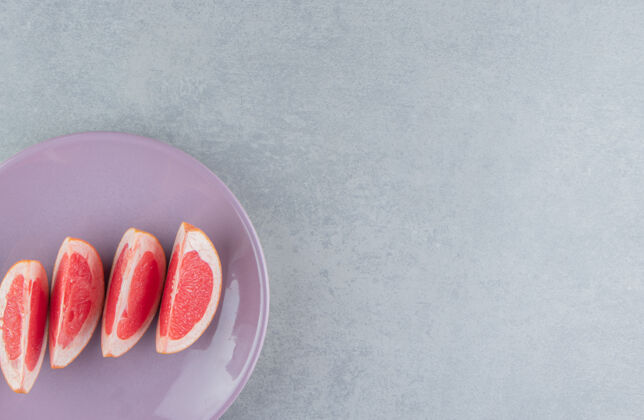 拼盘一份葡萄柚片放在大理石盘上美味营养柑橘