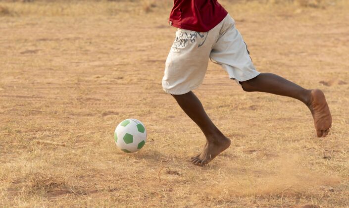 跑步特写男孩追球玩非洲足球比赛