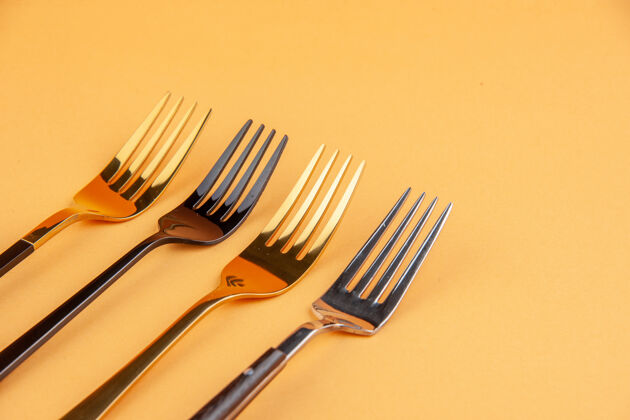 晚餐半拍优雅闪亮的不锈钢叉子上孤立的金色背景与自由空间匙银器餐具