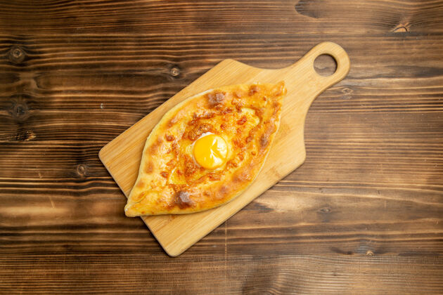 晚餐俯瞰美味的鸡蛋面包在棕色的木制桌子上烤面包包烤早餐鸡蛋蔬菜西红柿午餐