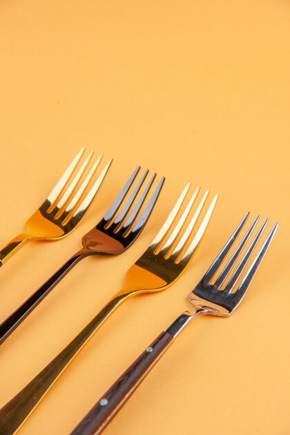 钢在独立的金色背景上 用自由空间近距离观看优雅闪亮的不锈钢叉子封闭午餐工具