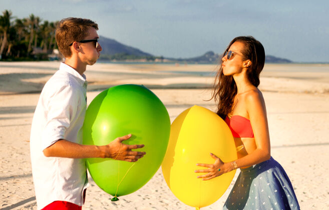 情侣两个快乐的年轻人在沙滩上约会和玩耍的可爱肖像搞笑外遇热带
