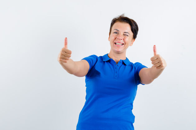 柔软穿着蓝色t恤的成熟女性向上竖起大拇指 看起来很开心正面视图显示皮肤健康