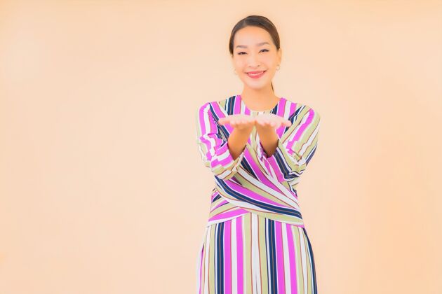 漂亮肖像美丽的亚洲年轻女子微笑放松在行动上的色彩欢呼壁板年轻