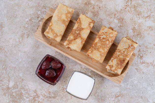 美味用美味的薄饼和草莓酱做成的木板有机食物煎饼