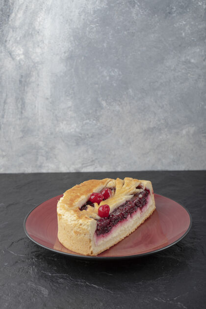 面包房美味的芝士蛋糕切片和浆果放在红色盘子里美味食品新鲜