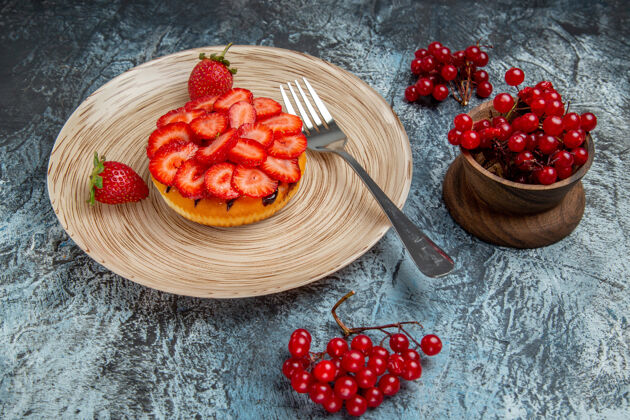 可食用水果正面是美味的草莓蛋糕和浆果在黑暗的表面派草莓蛋糕