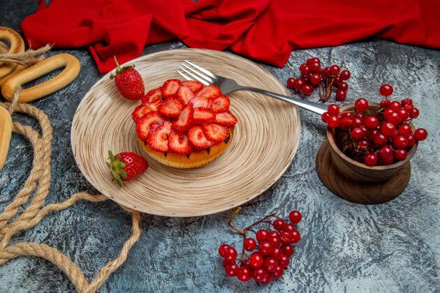 成熟正面是美味的草莓蛋糕和浆果在黑暗的表面甜点草莓深色