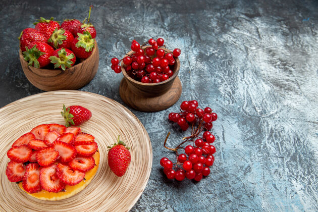成熟深色表面上有新鲜草莓的水果蛋糕正面图饮食正面浆果