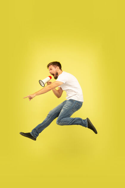 男性黄色背景上孤立的快乐跳跃人的全长肖像穿着休闲服的白人男模自由选择 灵感 人类情感概念用嘴和平呼唤办公室牛仔裤男孩