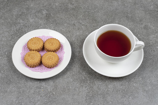 食品美味的圆形饼干和一杯茶放在大理石表面面包房杯小吃