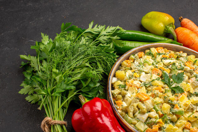 食物正面近距离观看美味的沙拉 在黑暗的表面上有绿色和蔬菜午餐饮食蔬菜