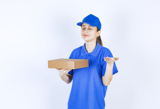 服务穿着蓝色制服的女孩拿着一个纸板外卖盒 闻着食物的味道工人员工女性