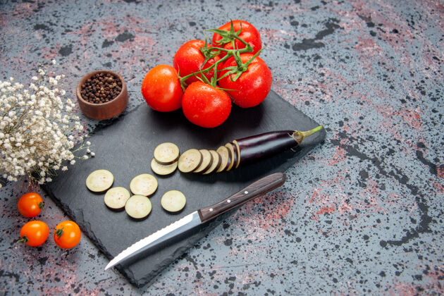 新鲜正面图黑色茄子和新鲜的红色西红柿蓝色背景西红柿晚餐刀