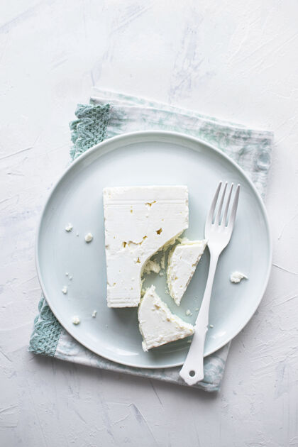 食谱用叉子平放在白色盘子上的羊乳酪最低限度晚餐可食食品