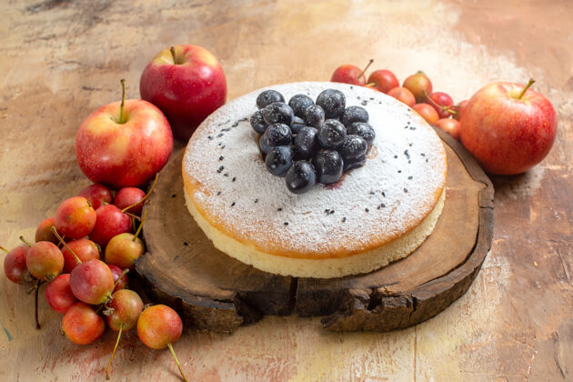 甜点浆果一种开胃的蛋糕 在木板上放着葡萄苹果和浆果壁板小吃蛋糕