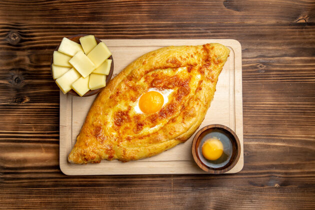 晚餐顶视图新鲜的烤面包和煮熟的鸡蛋放在木制桌子上面团餐包早餐鸡蛋食品面包烘焙膳食