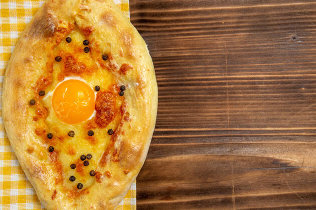 奶酪顶部近距离观看美味的鸡蛋面包新鲜离开烤箱在木制桌子上吃面包面包包早餐鸡蛋新鲜晚餐午餐
