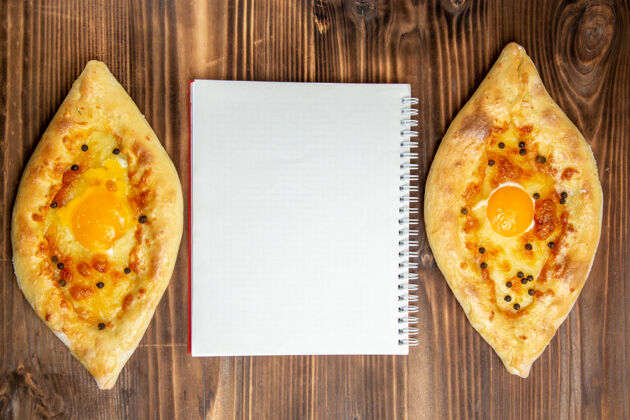 晚餐顶视图烤鸡蛋面包从棕色木制书桌上的烤箱新鲜出炉面团鸡蛋面包包早餐面包用餐烤箱
