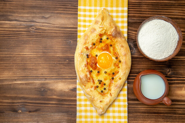 烤箱俯视图美味的鸡蛋面包新鲜出炉 牛奶放在木桌上 面团烤面包 包鸡蛋烘焙景观奶酪