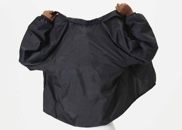 品牌一个穿着黑色夹克的黑人妇女的后视图模型防水夹克穿
