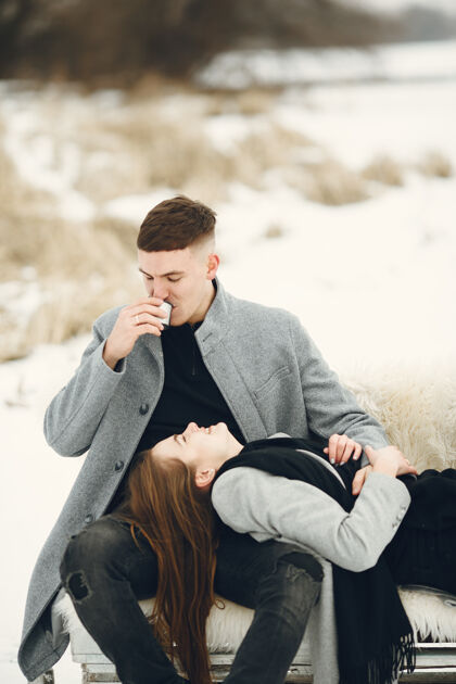 在一起一对夫妇在雪林中的生活方式照片人们在户外度过寒假外套女孩情侣