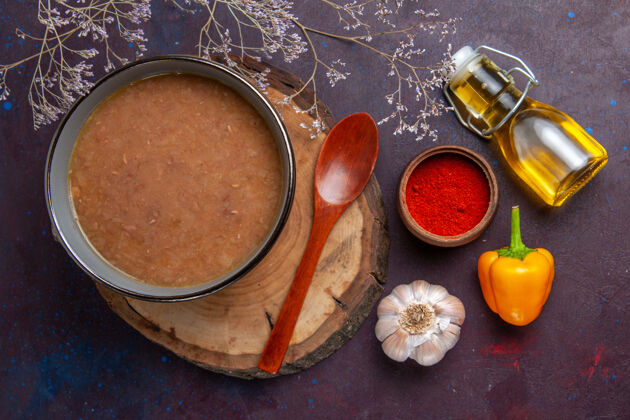 油漆顶视图褐色的橄榄油和大蒜汤在黑暗的表面汤蔬菜餐食品菜豆豆类生刷子