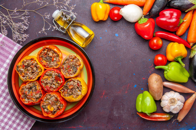 饮食顶视图煮熟的甜椒与地面肉和新鲜蔬菜在黑暗的表面一餐蔬菜食物肉多尔玛水果生的西红柿