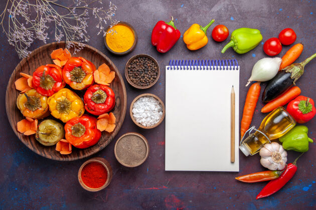 饮食顶视图熟甜椒与调味品和新鲜蔬菜的灰色表面一餐蔬菜肉多尔玛食品生的膳食蔬菜