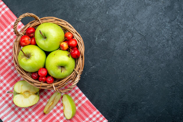 篮子顶视图篮子上有水果苹果和甜樱桃 背景为深灰色 水果浆果成分新鲜 树上有植物苹果可食用的水果樱桃