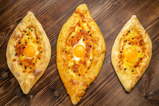 早餐顶视图烤鸡蛋面包从棕色桌子上烤箱新鲜的面团鸡蛋面包包早餐面包面包新鲜