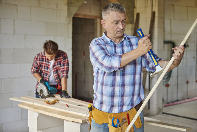 锤子积极的木匠使用锤子在主计划工艺建筑车间