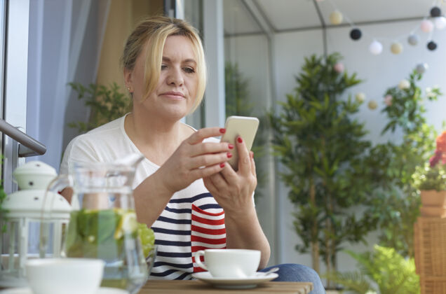 休息阳台上喝咖啡的女人的特写照片休闲服支票厚颜无耻