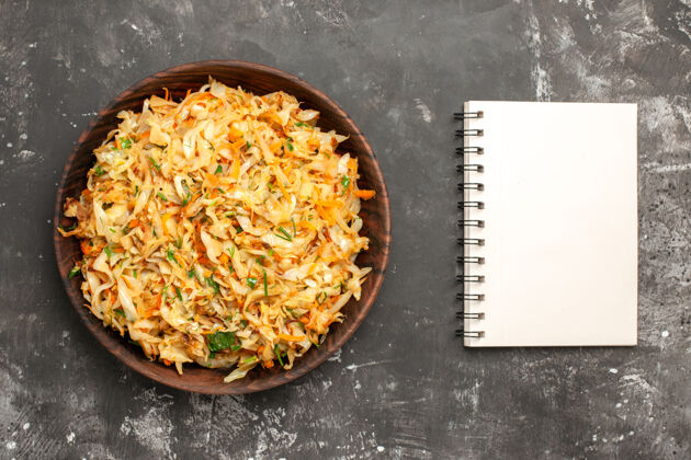 笔记本顶视图白菜胡萝卜碗白菜胡萝卜旁边的笔记本餐厅卷心菜与胡萝卜美味
