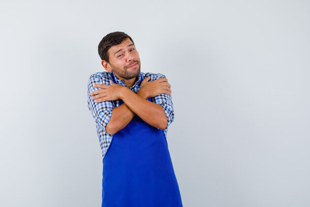 衬衫穿着蓝色围裙和衬衫的年轻男厨师帅哥成人男士