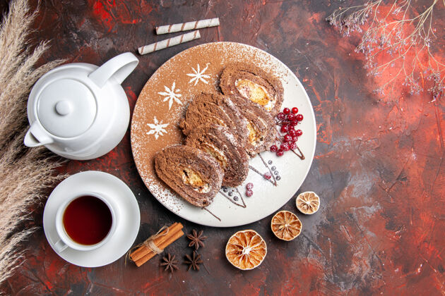 早上俯瞰美味饼干卷和一杯茶在黑暗的桌子上派蛋糕黑的